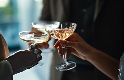 a close-up of hands holding glasses of wine