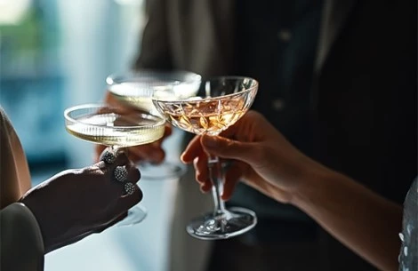 a close-up of hands holding glasses of wine