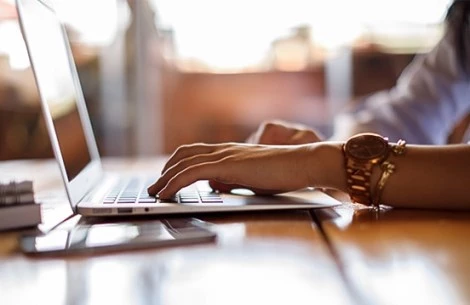 a close-up of a person typing on a laptop