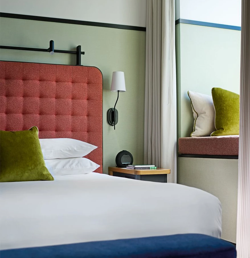 a bed with pillows and a lamp in a room