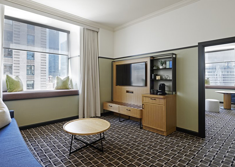 a suite living room with a tv and a table