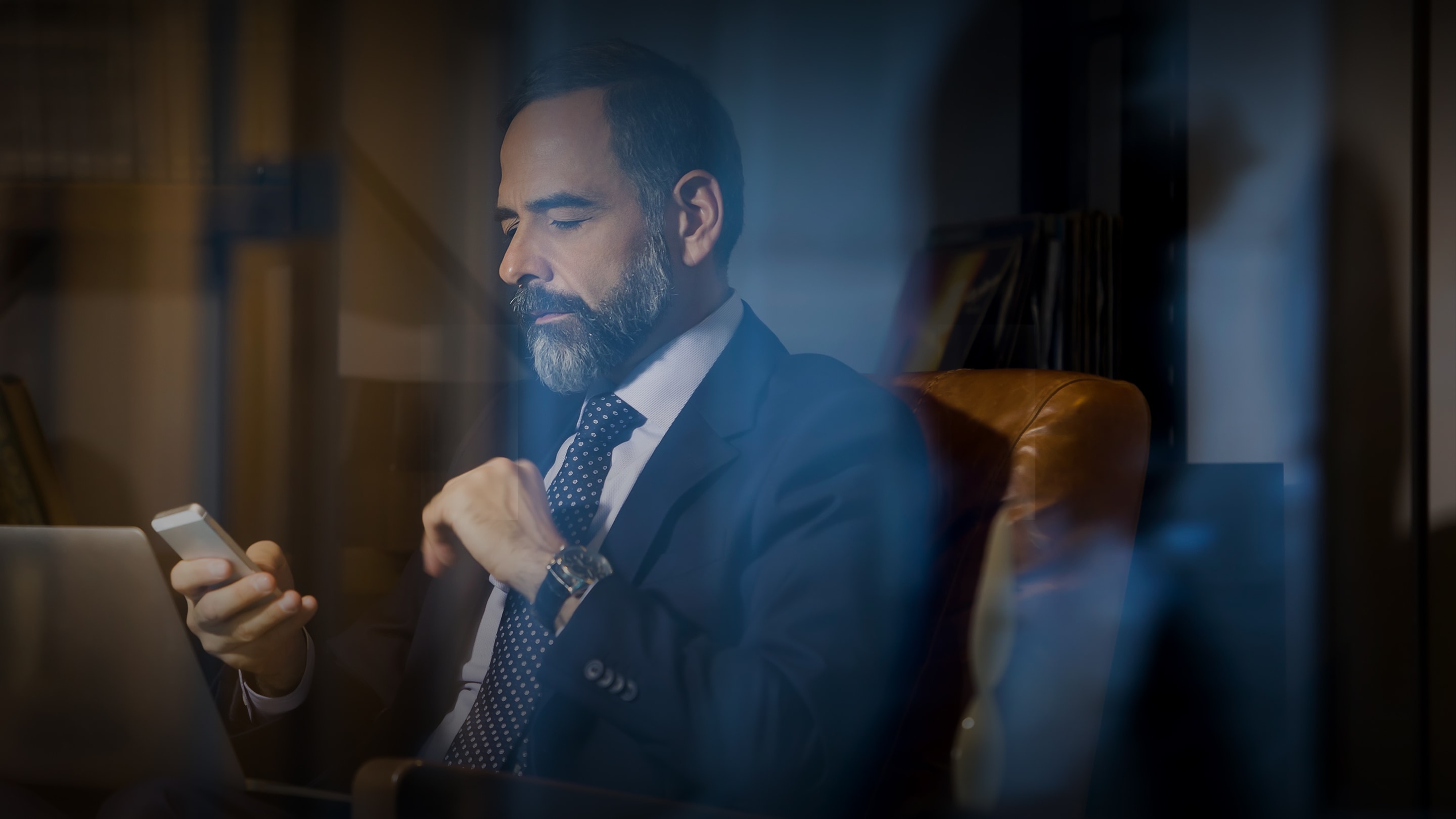 a man in a suit looking at his phone