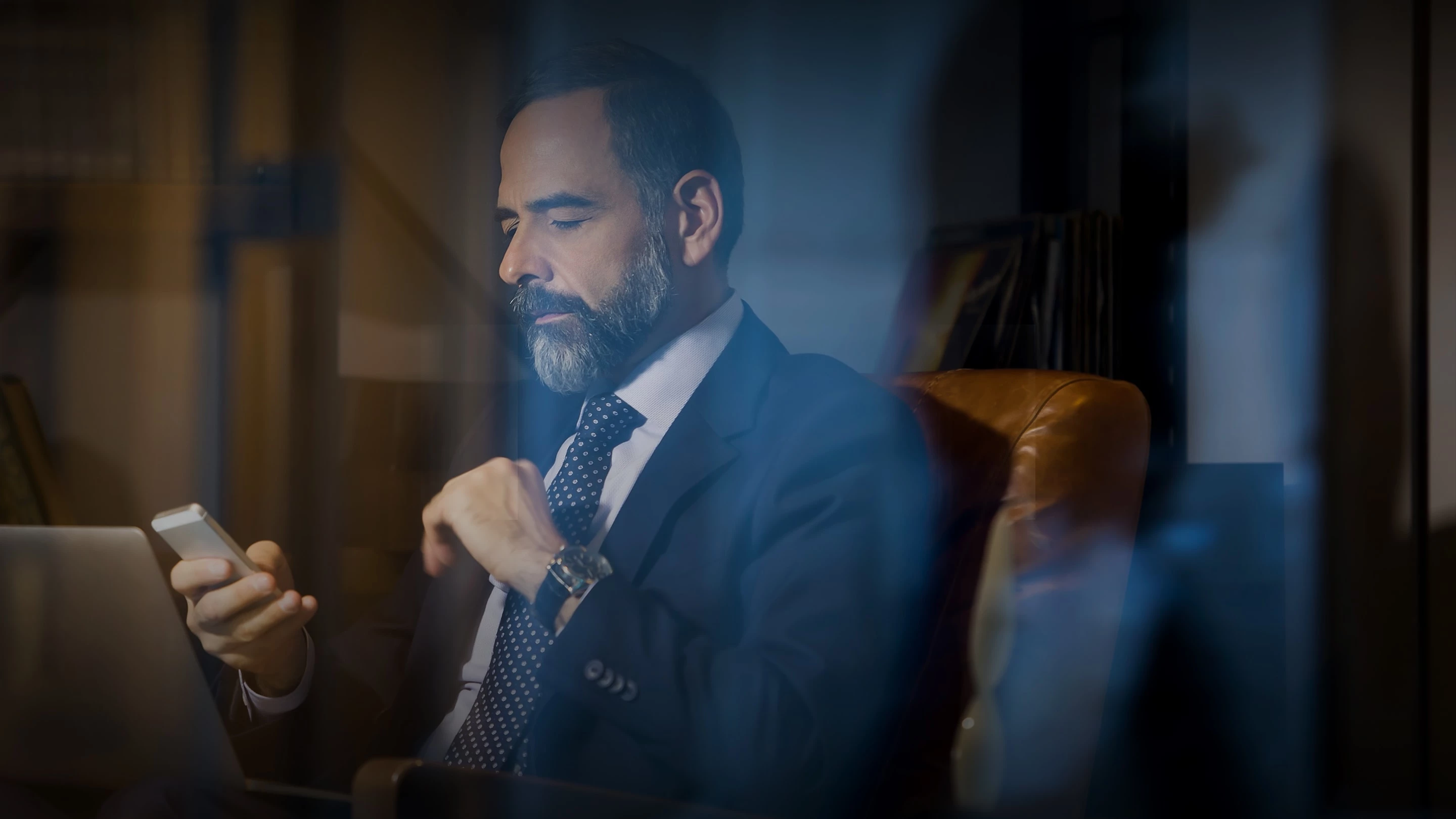 a man in a suit looking at his phone