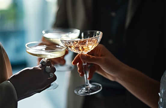 a close-up of hands holding glasses of wine