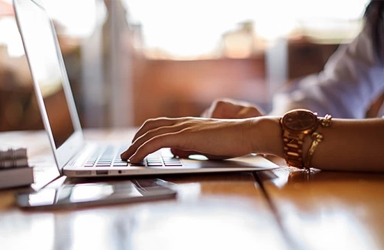 a close-up of a person typing on a laptop