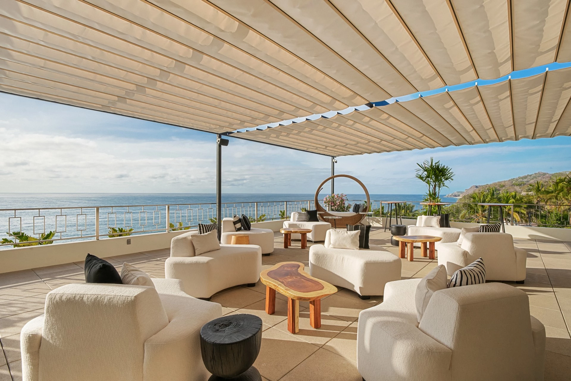 a patio with white furniture and a large white umbrella over it