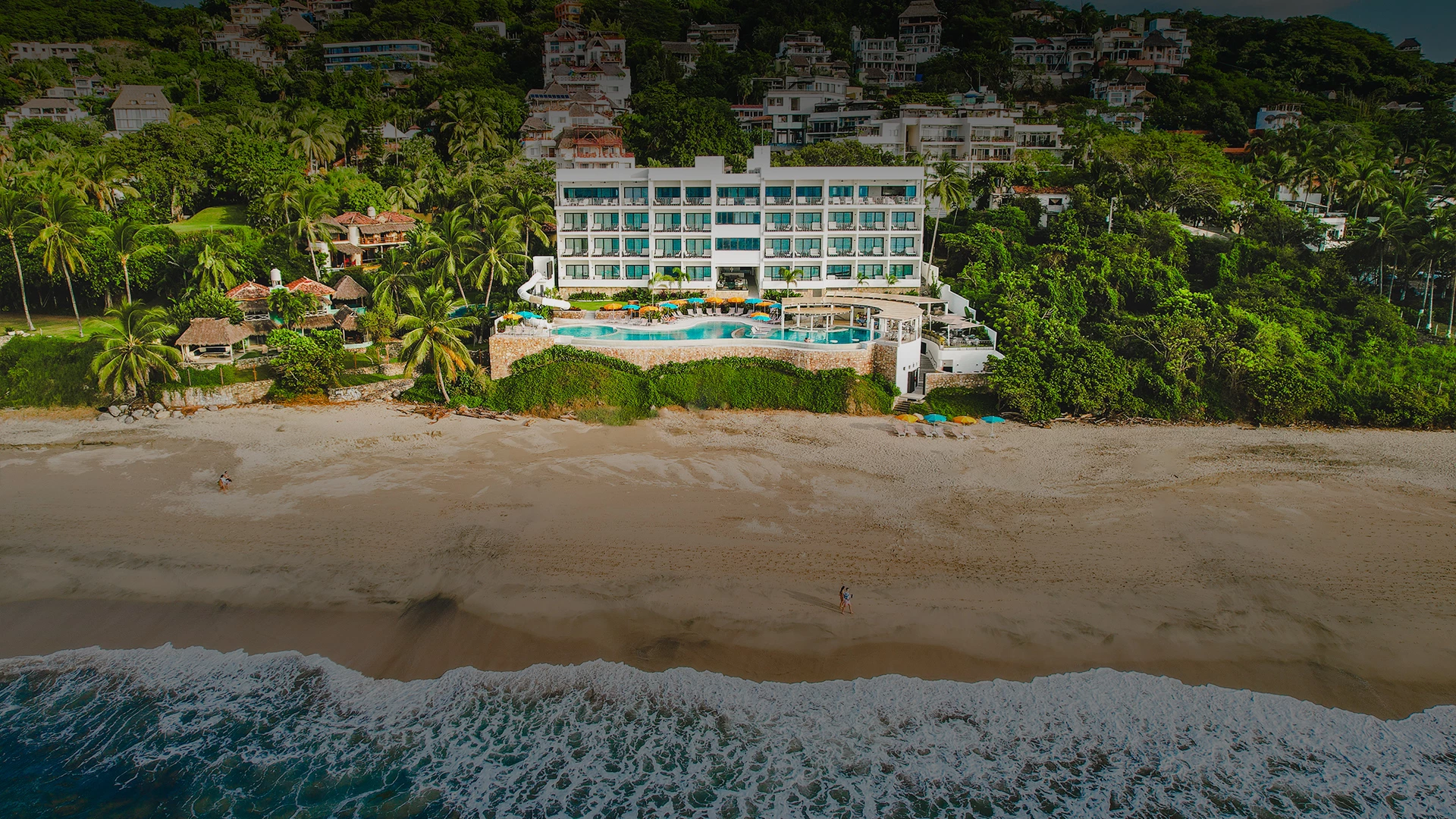 a beach with a building and a pool