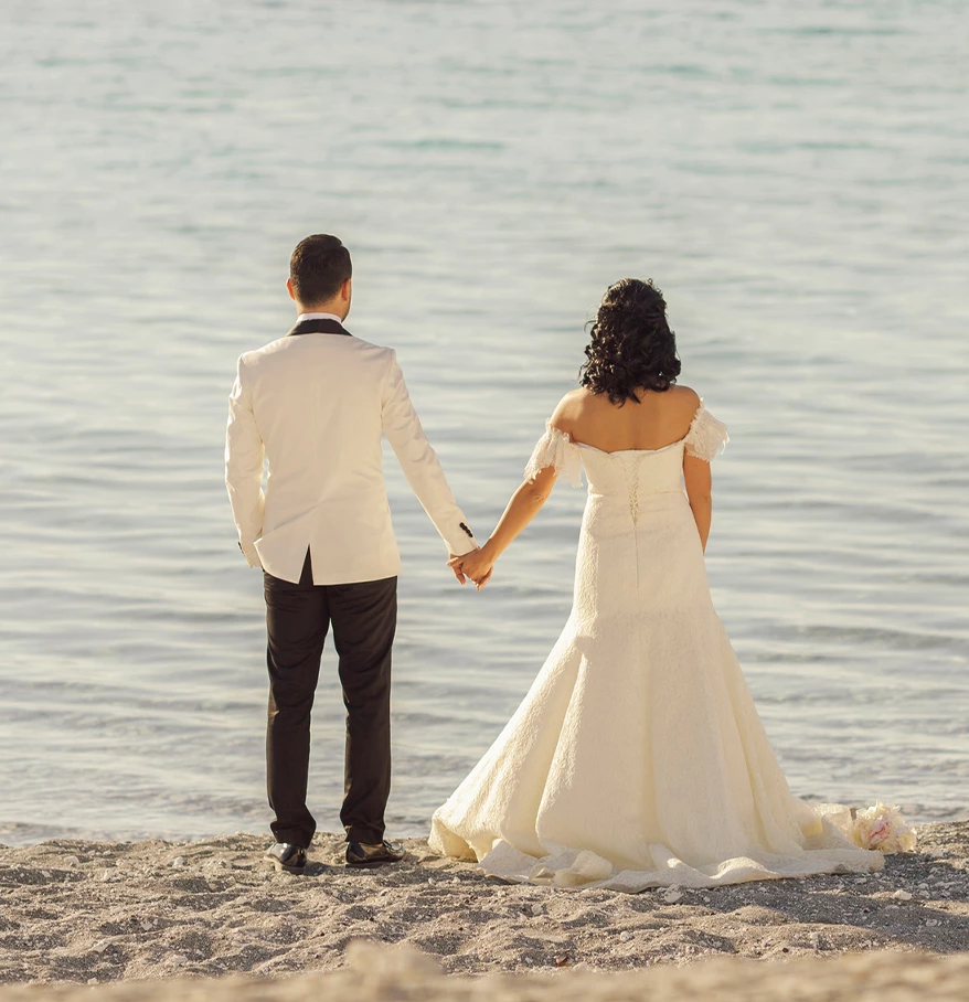 a man and woman holding hands on a beach