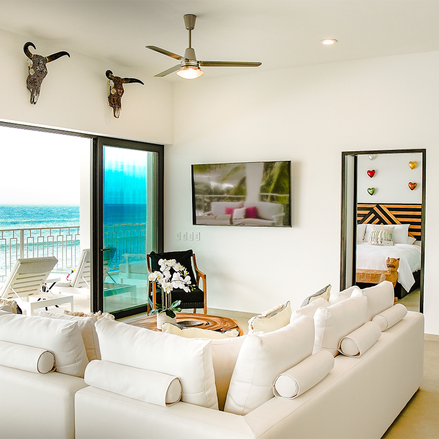 a room with a couch and a view of the ocean