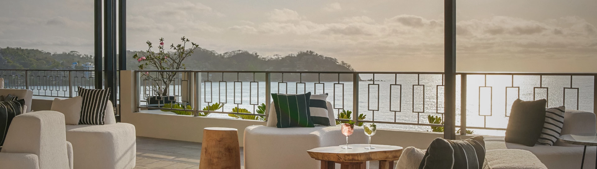 a chair and two drinks on a balcony