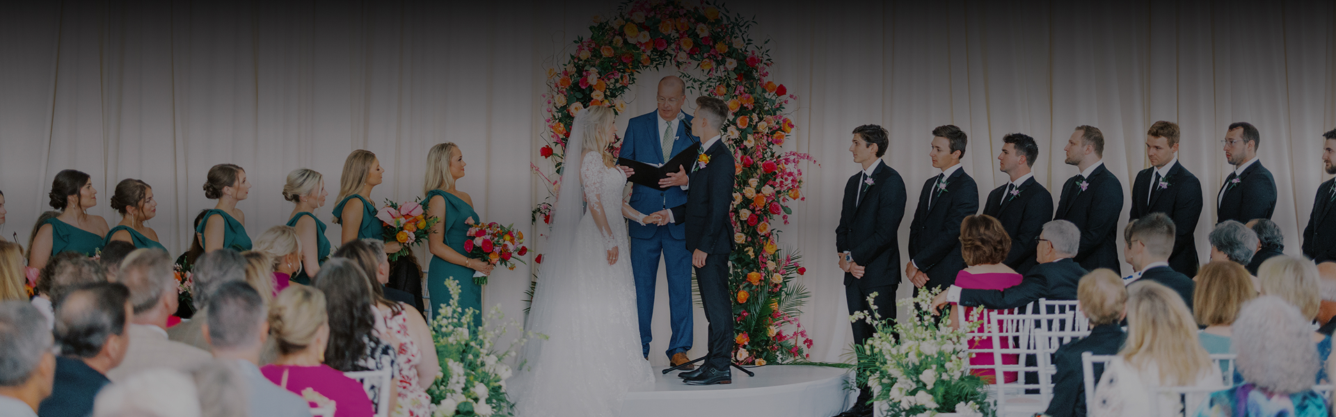 a man in a suit and a woman in a white dress standing on a stage with a man in a suit and a woman in a white dress