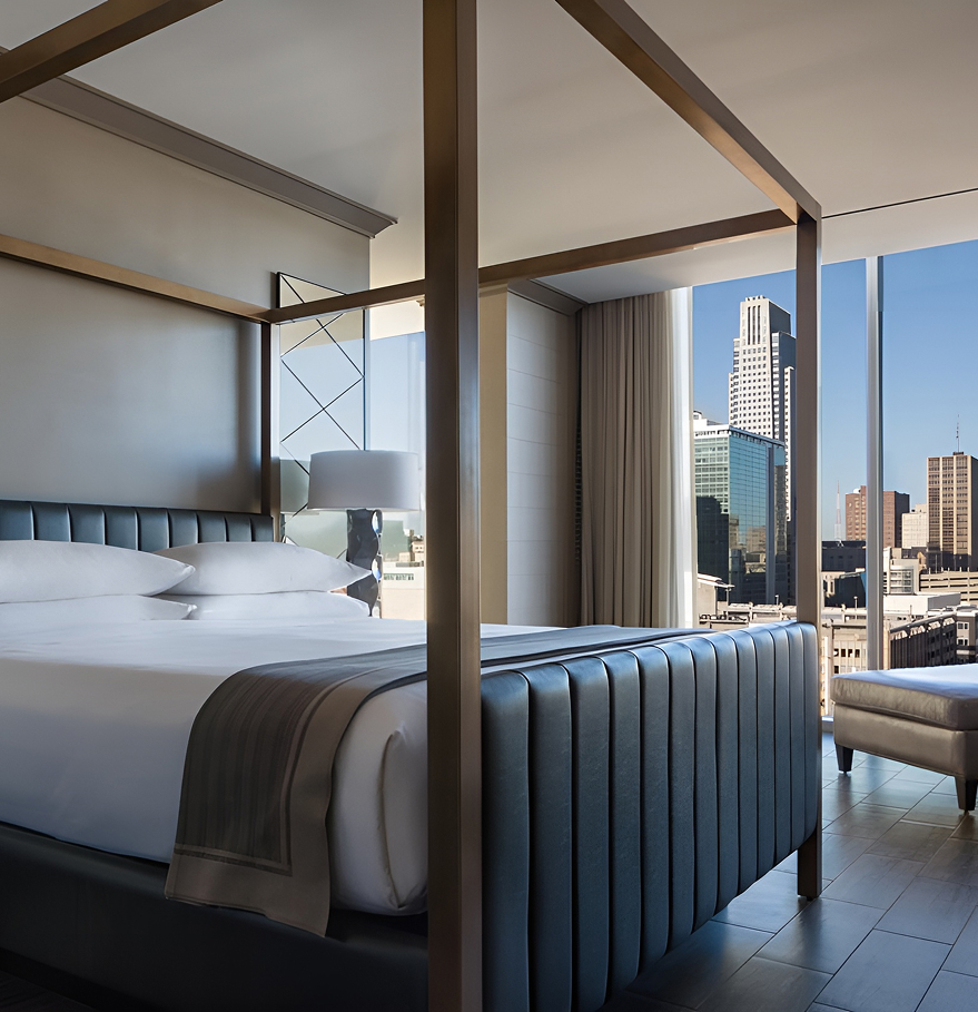 a bedroom with a four poster bed and a city view