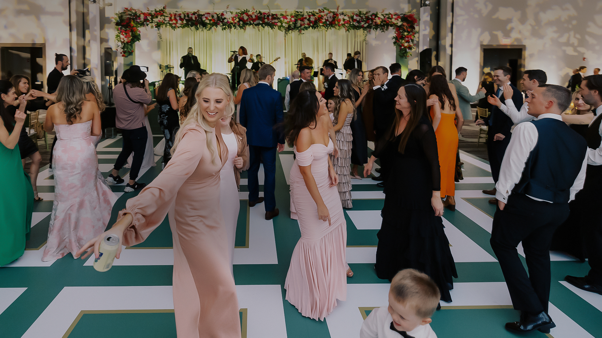 a group of women dancing in a room with a boy in front of them