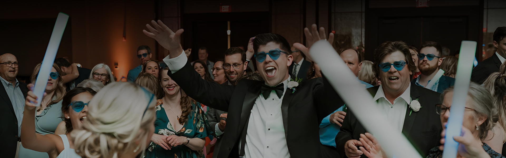a man in a tuxedo with his hands up
