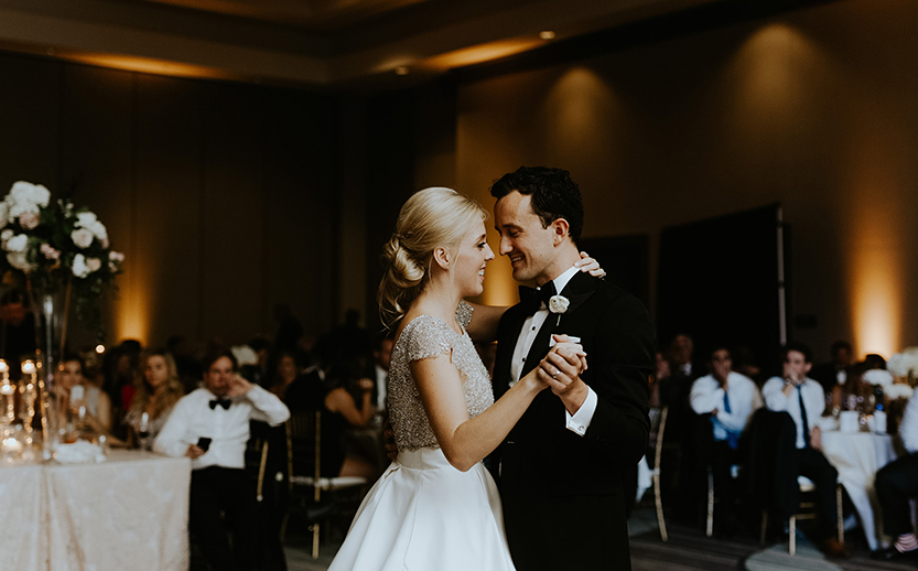 a man and woman dancing in a room with people in the background