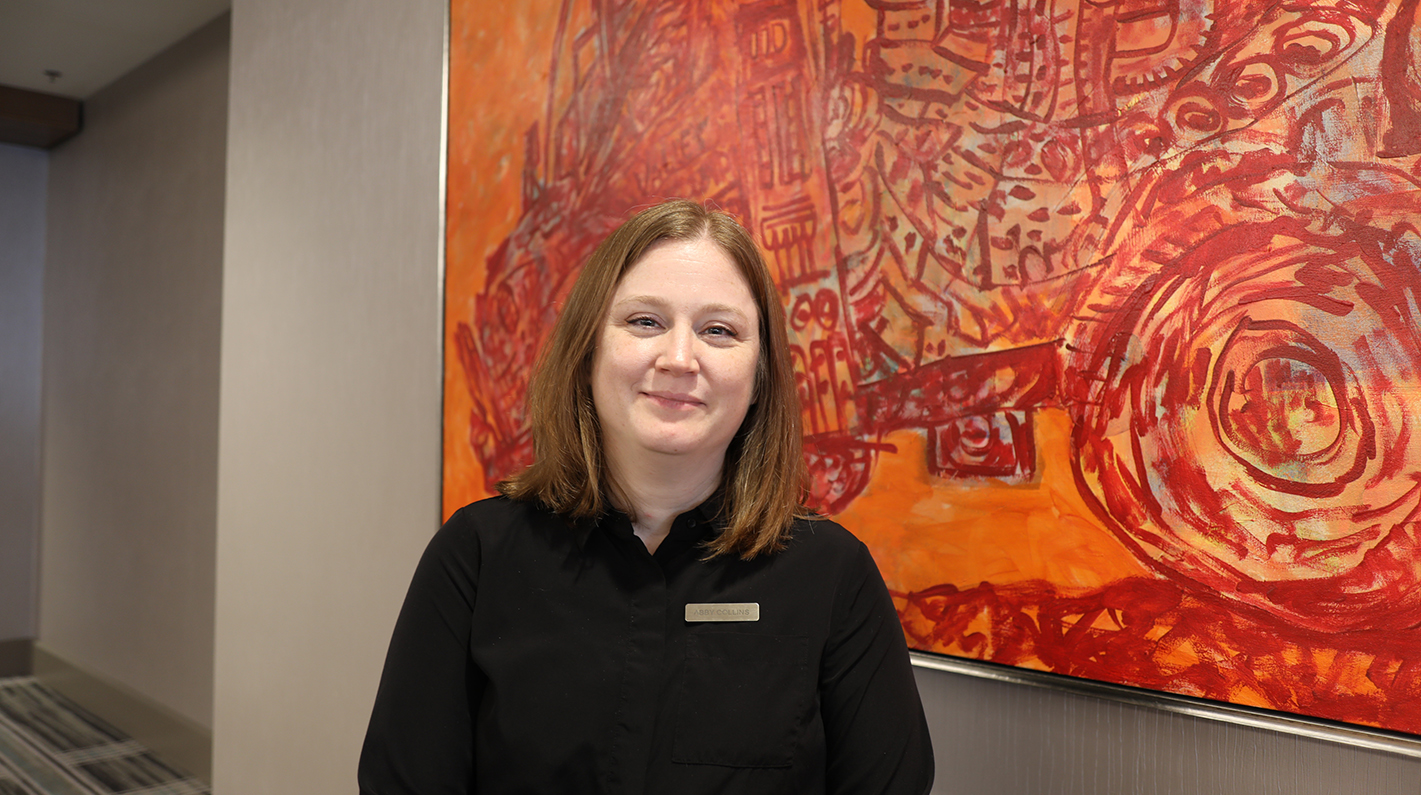 a woman standing in front of a painting