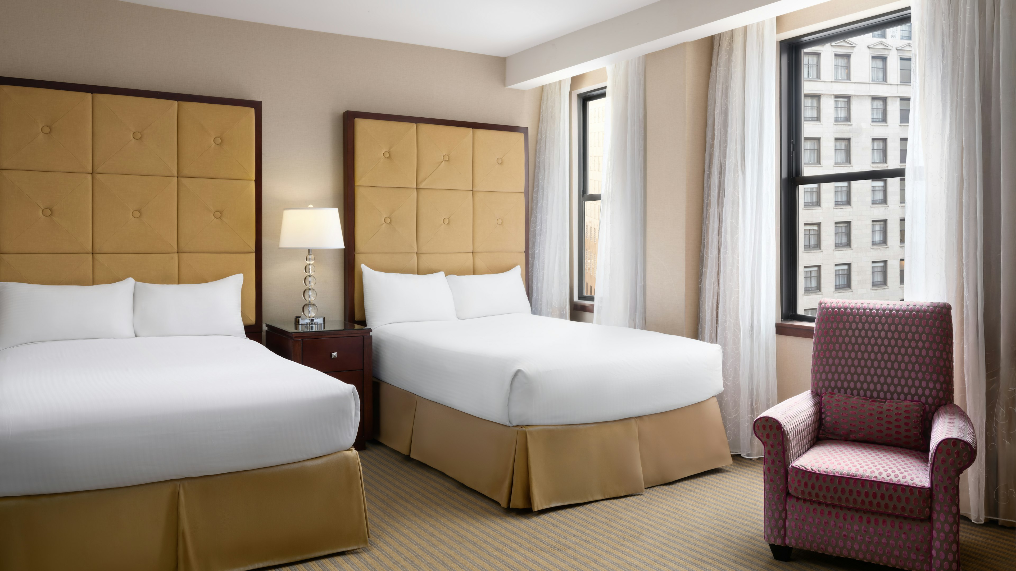 a room with two beds and a chair