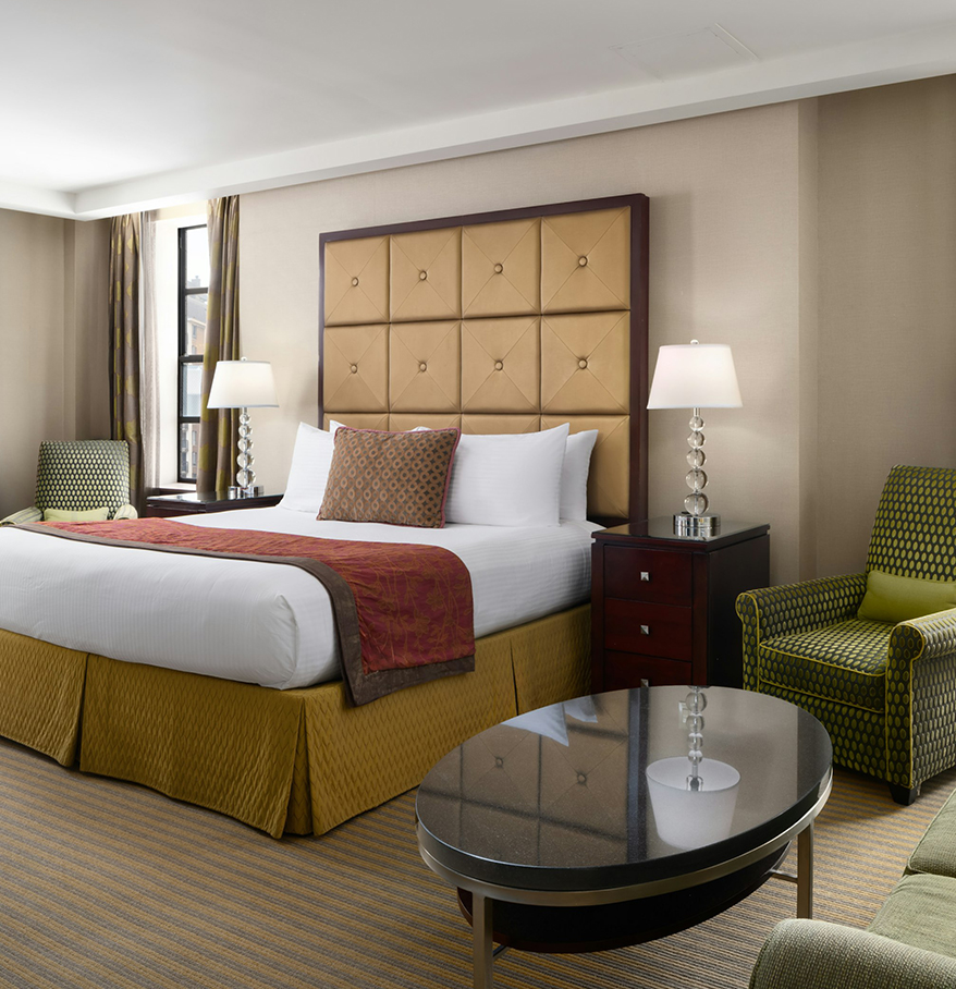a room with a bed and chairs