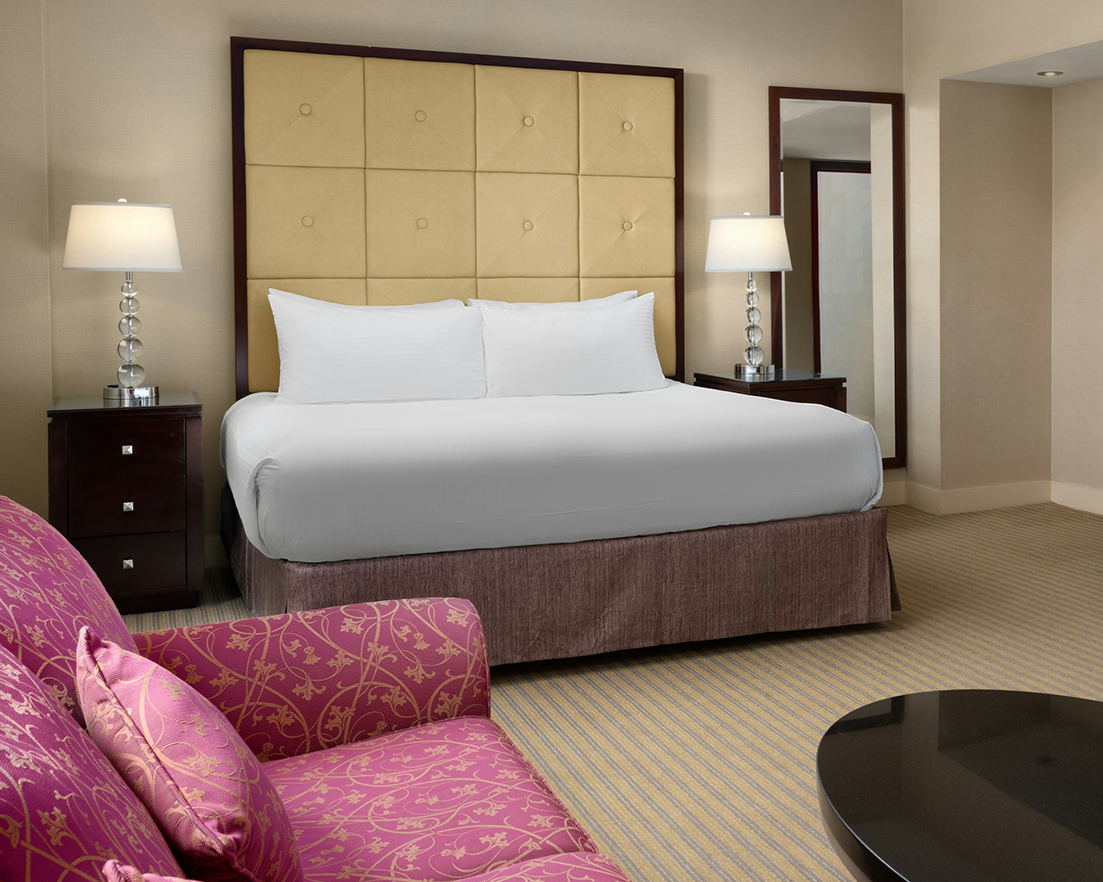 a hotel room with a bed and a pink couch