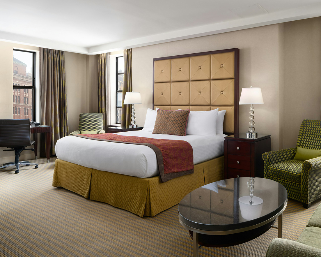 a room with a bed and chairs
