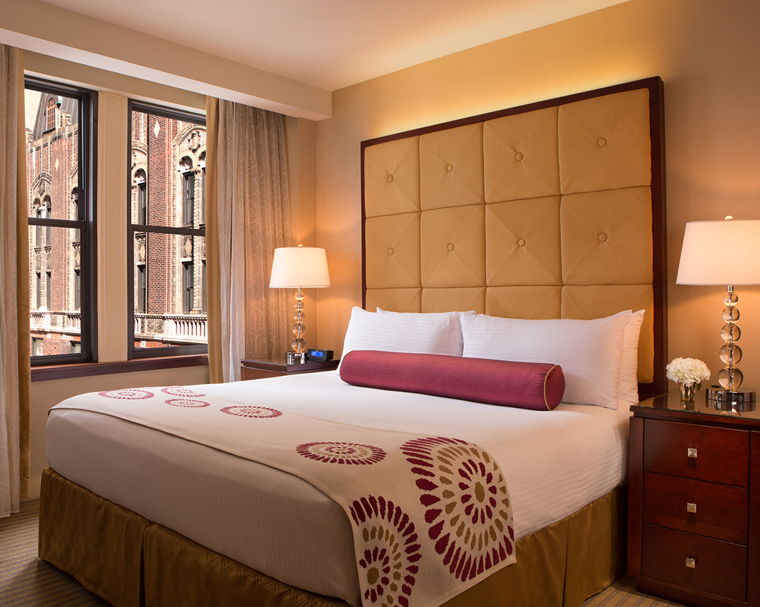 a bed with a large headboard and a lamp