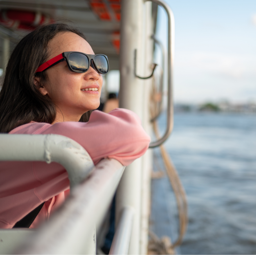 a woman wearing sunglasses leaning on a railing on a boat