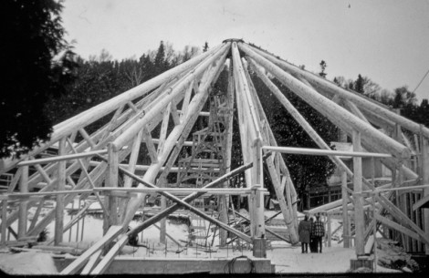 a structure under construction with people standing in front of trees