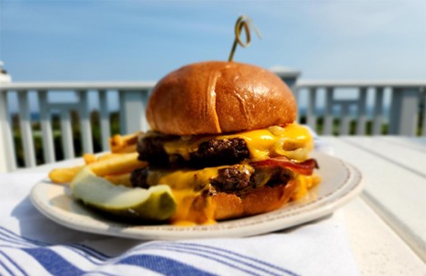 a cheeseburger with a pickle on a plate