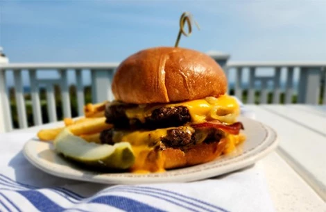 a cheeseburger with a pickle on a plate