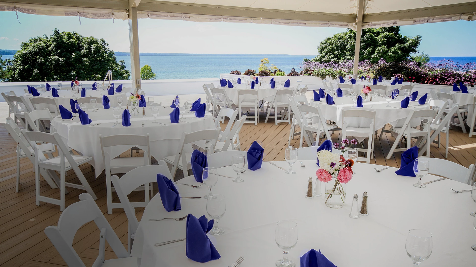 a set tables with white tables and blue napkins