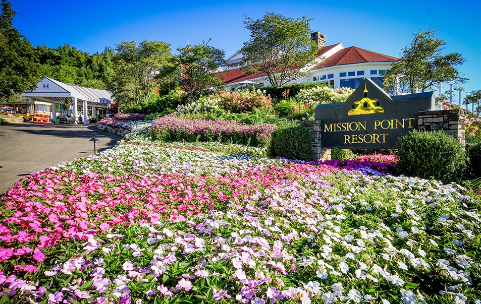 a sign with flowers in front of a building
