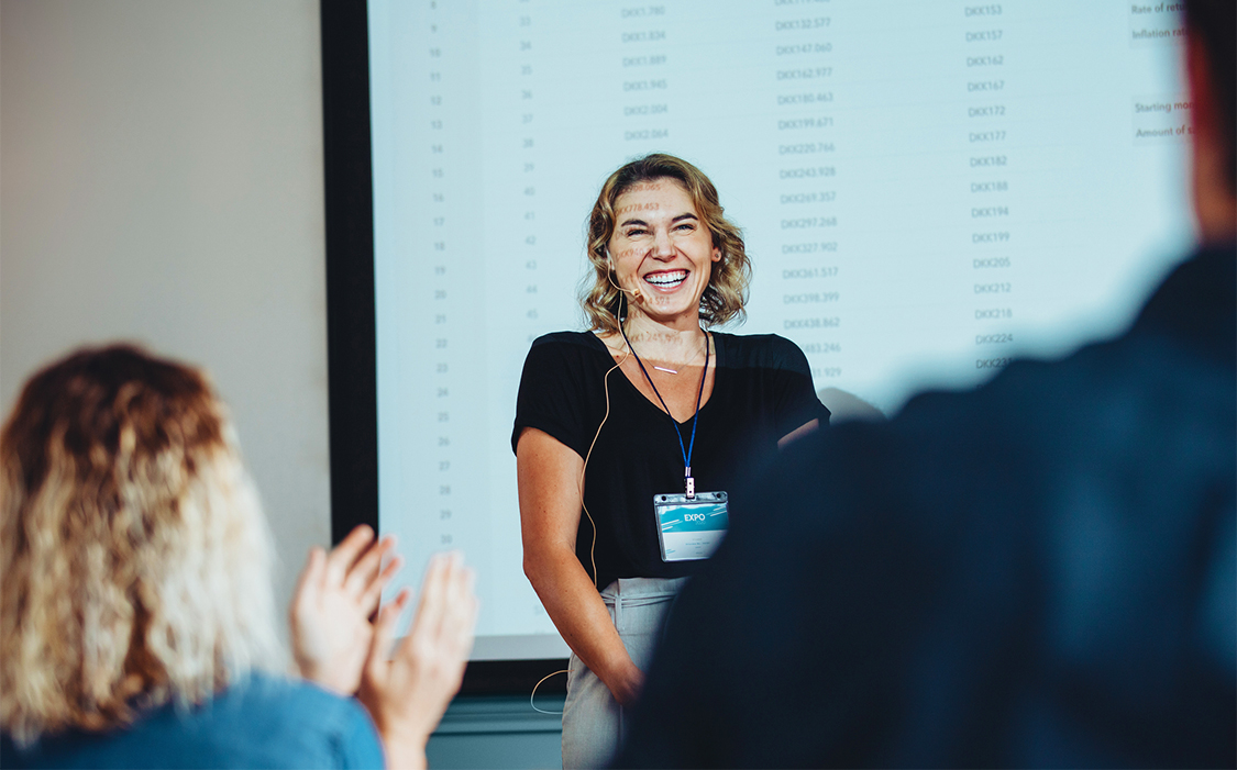 a woman standing in front of a projection screen