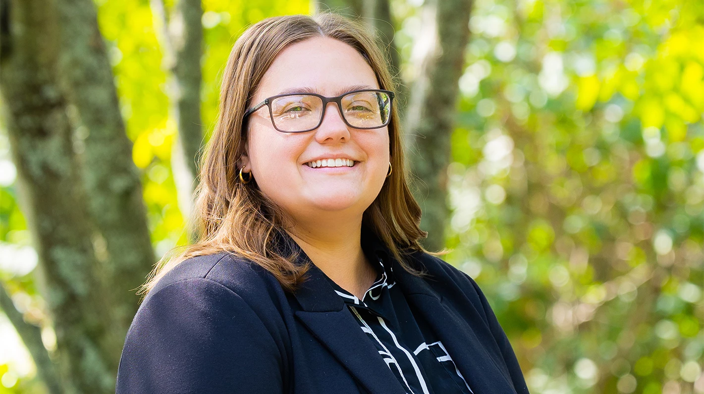a woman wearing glasses and smiling