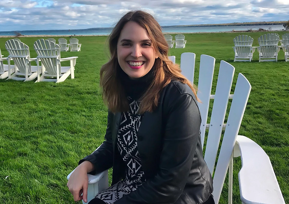 a woman sitting in a chair in front of a lawn