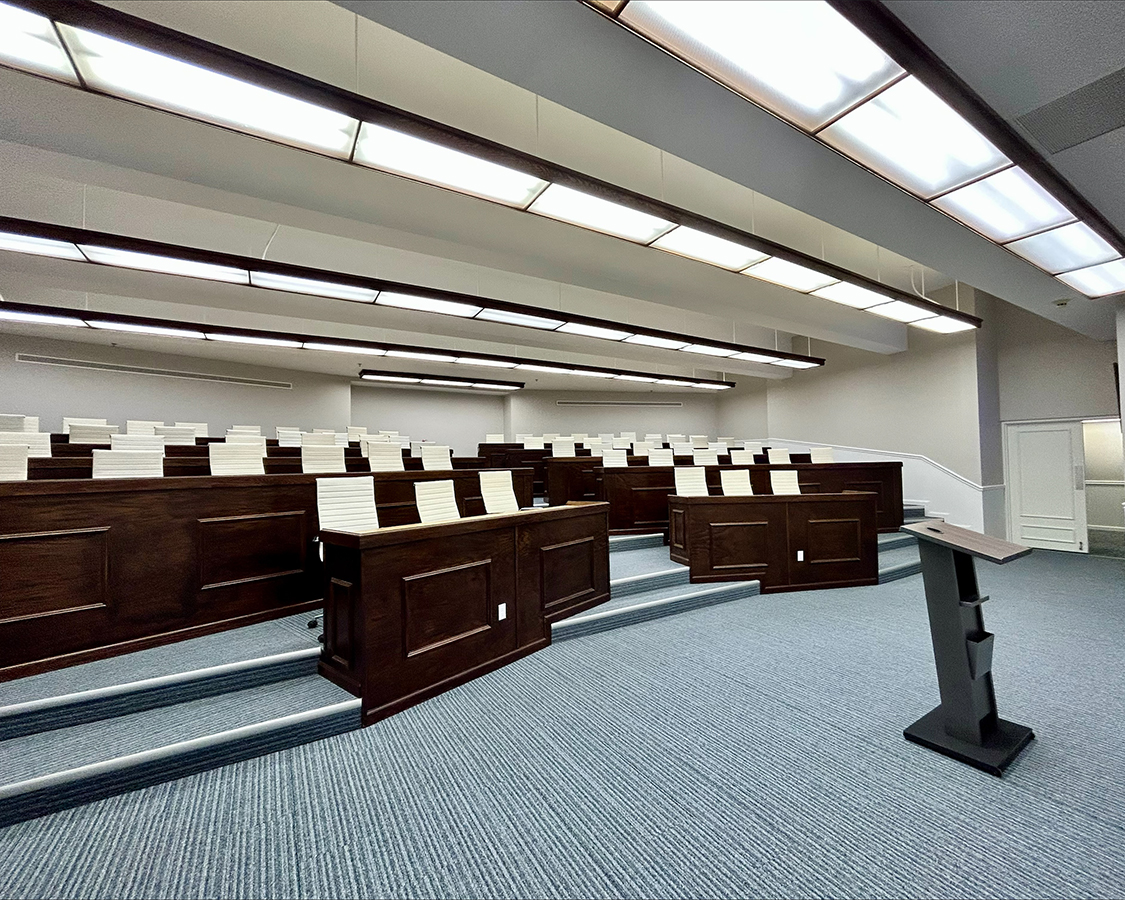 a room with rows of wooden benches and a podium
