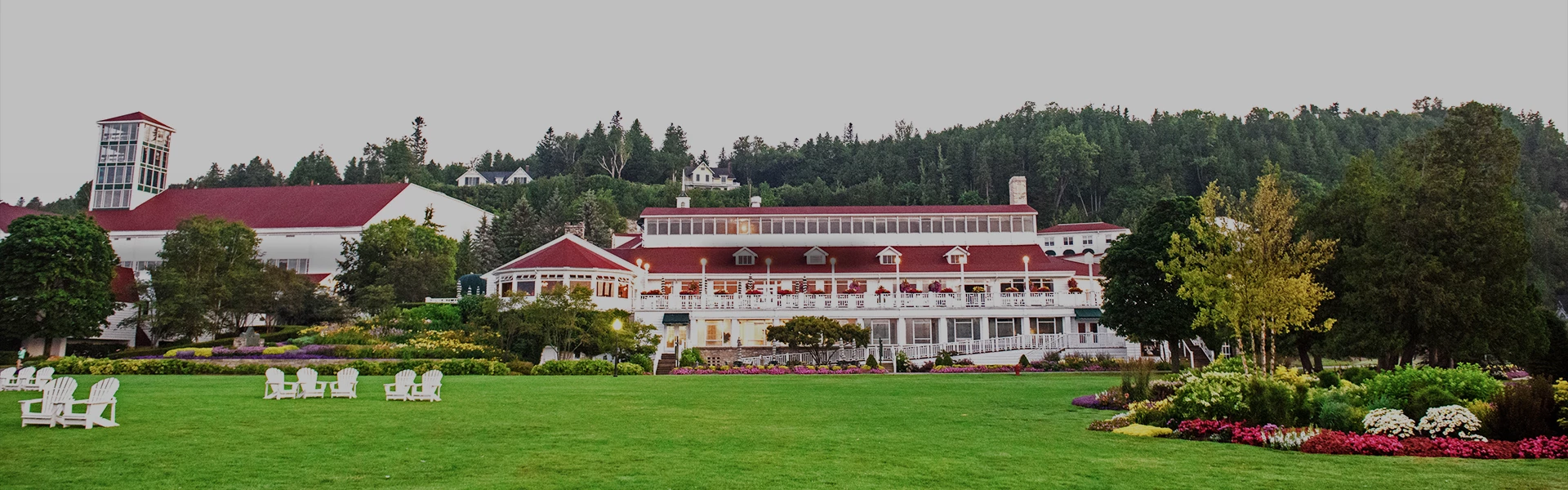 a large building with a lawn and trees in the background