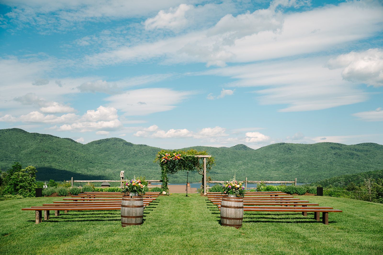 a wedding ceremony area with benches and flowers