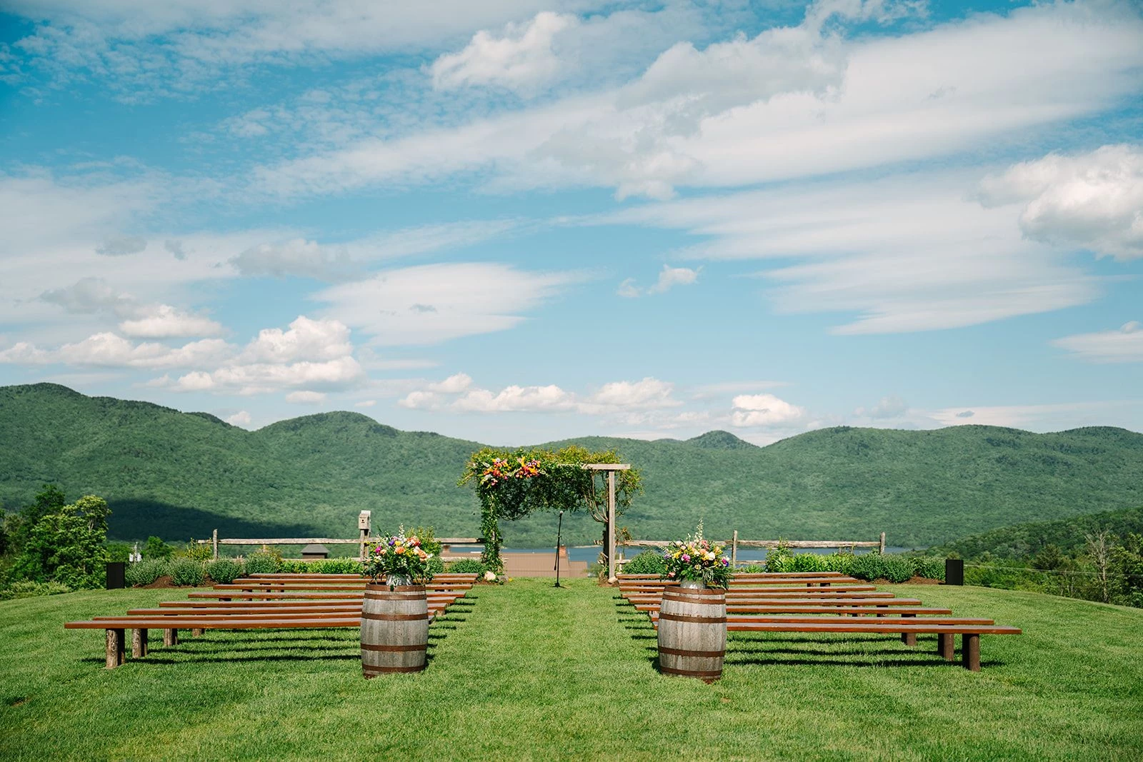 a wedding ceremony area with benches and flowers