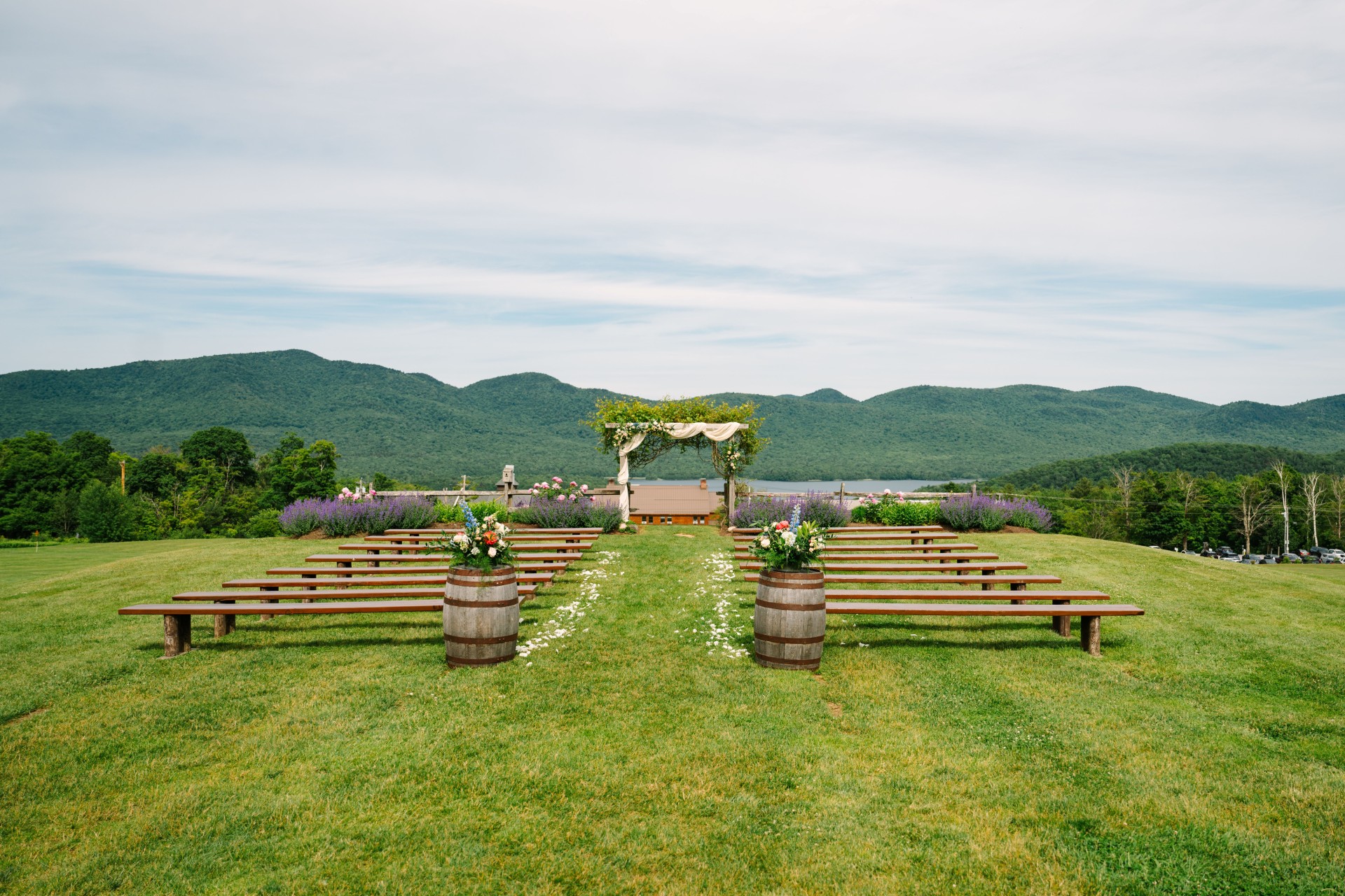 a wedding ceremony area with benches and barrels