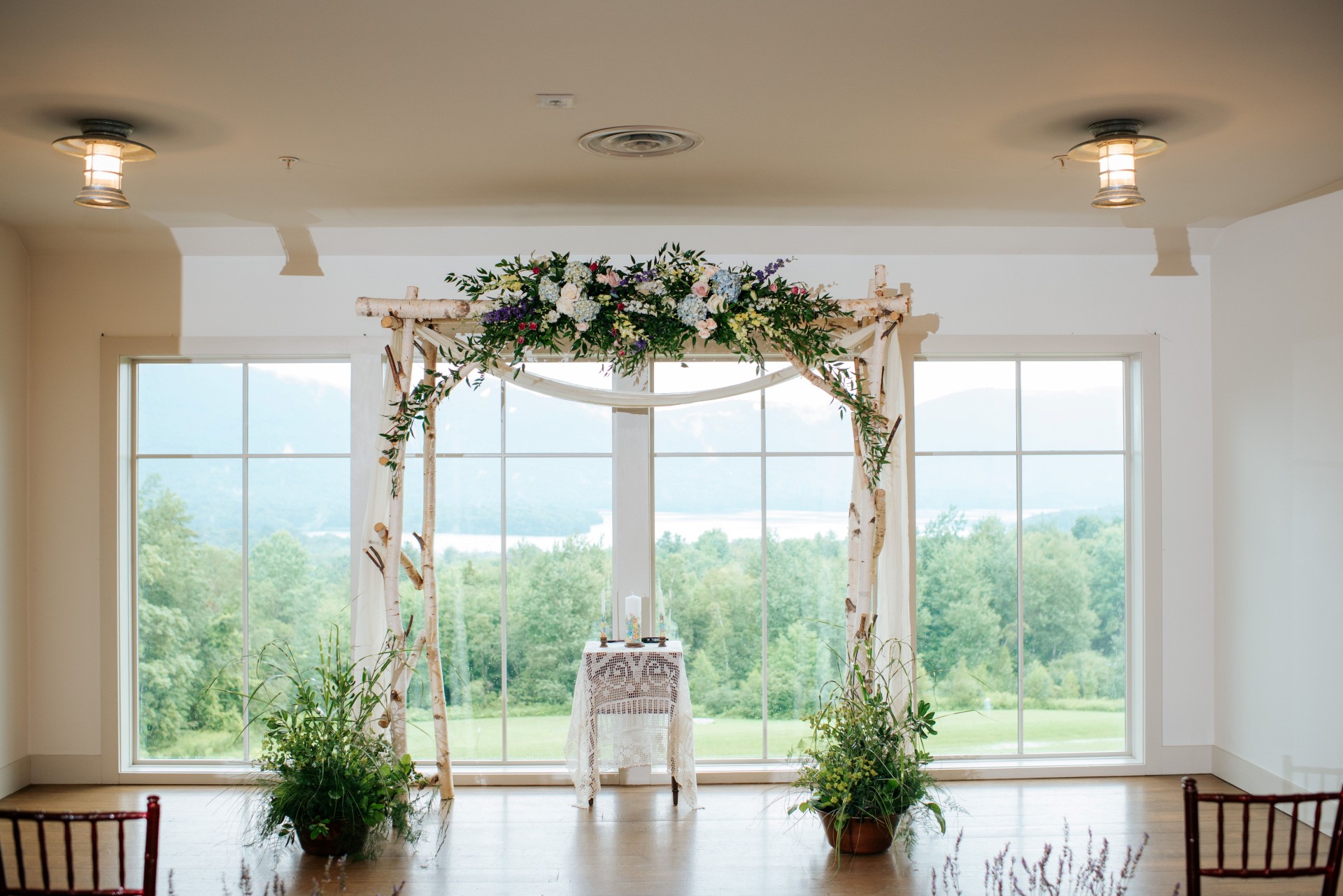 a wedding ceremony with a large window photo by Juniper Studios