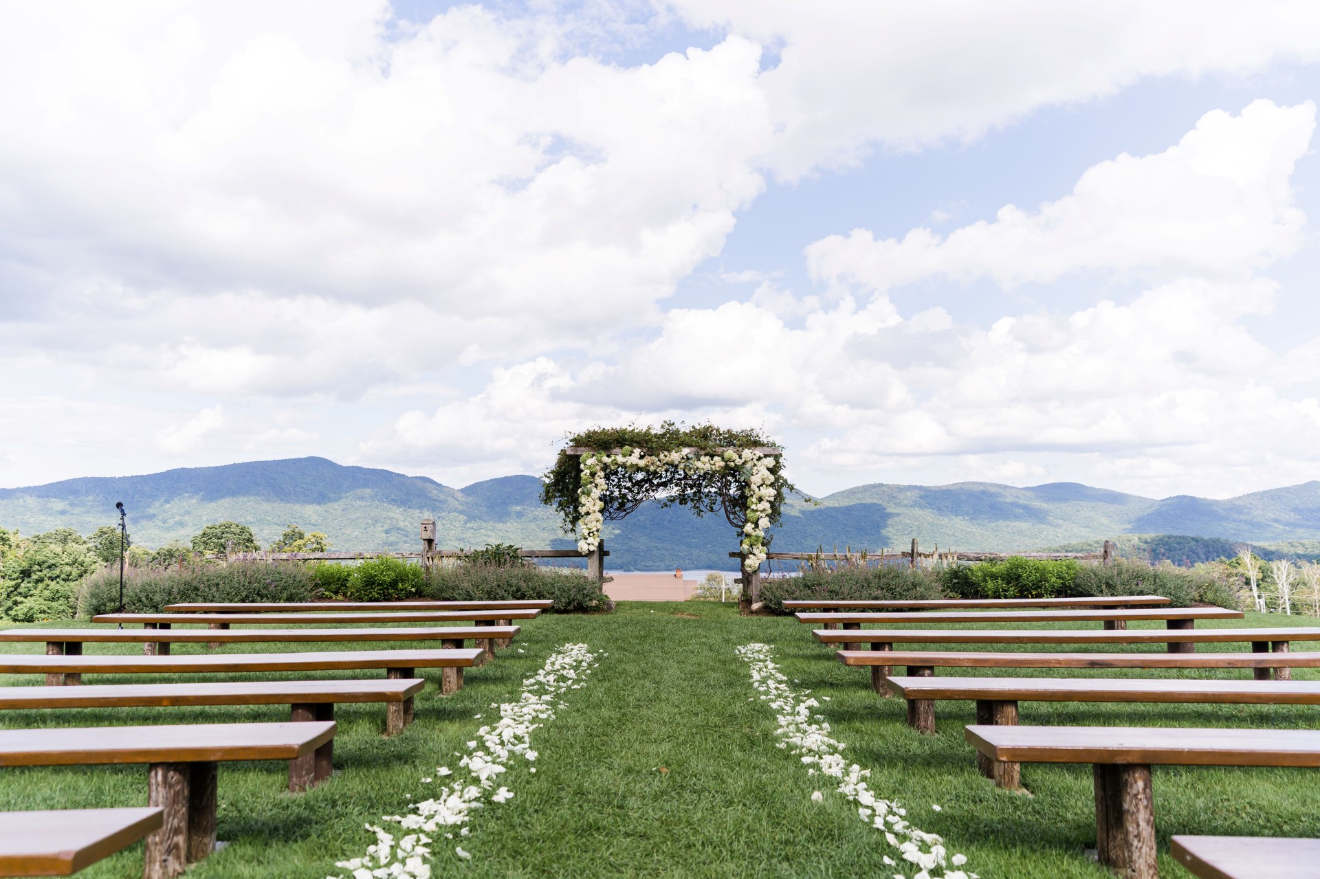 a wedding ceremony with benches and flowers