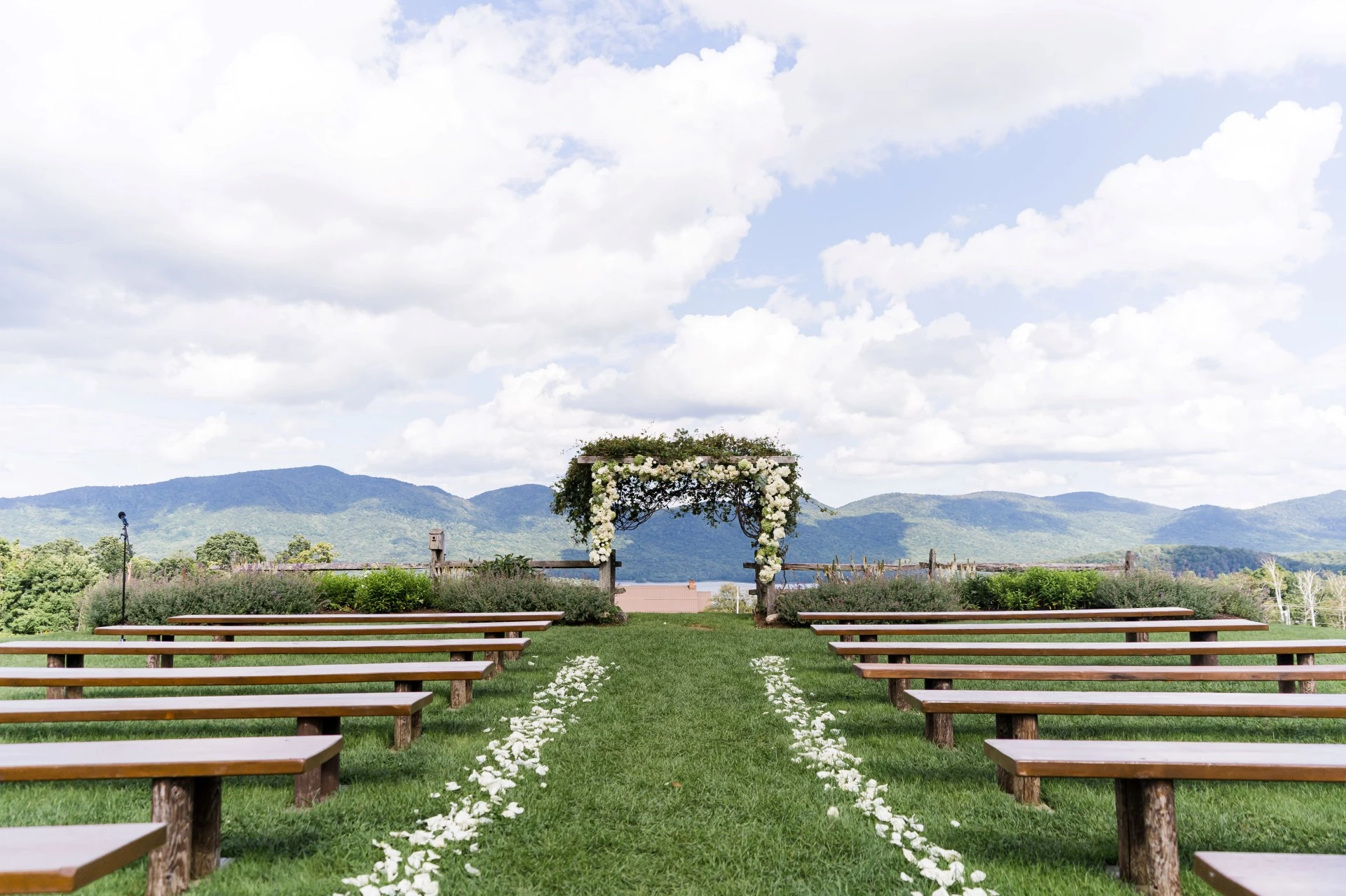 a wedding ceremony with benches and flowers
