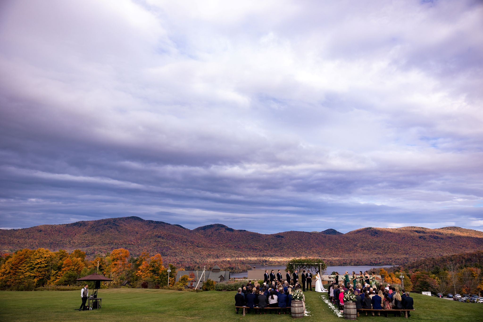a group of people standing on benches in a field with mountains in the background