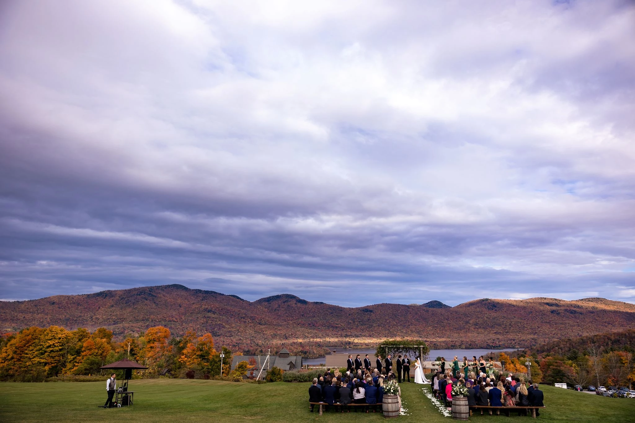 a group of people standing on benches in a field with mountains in the background