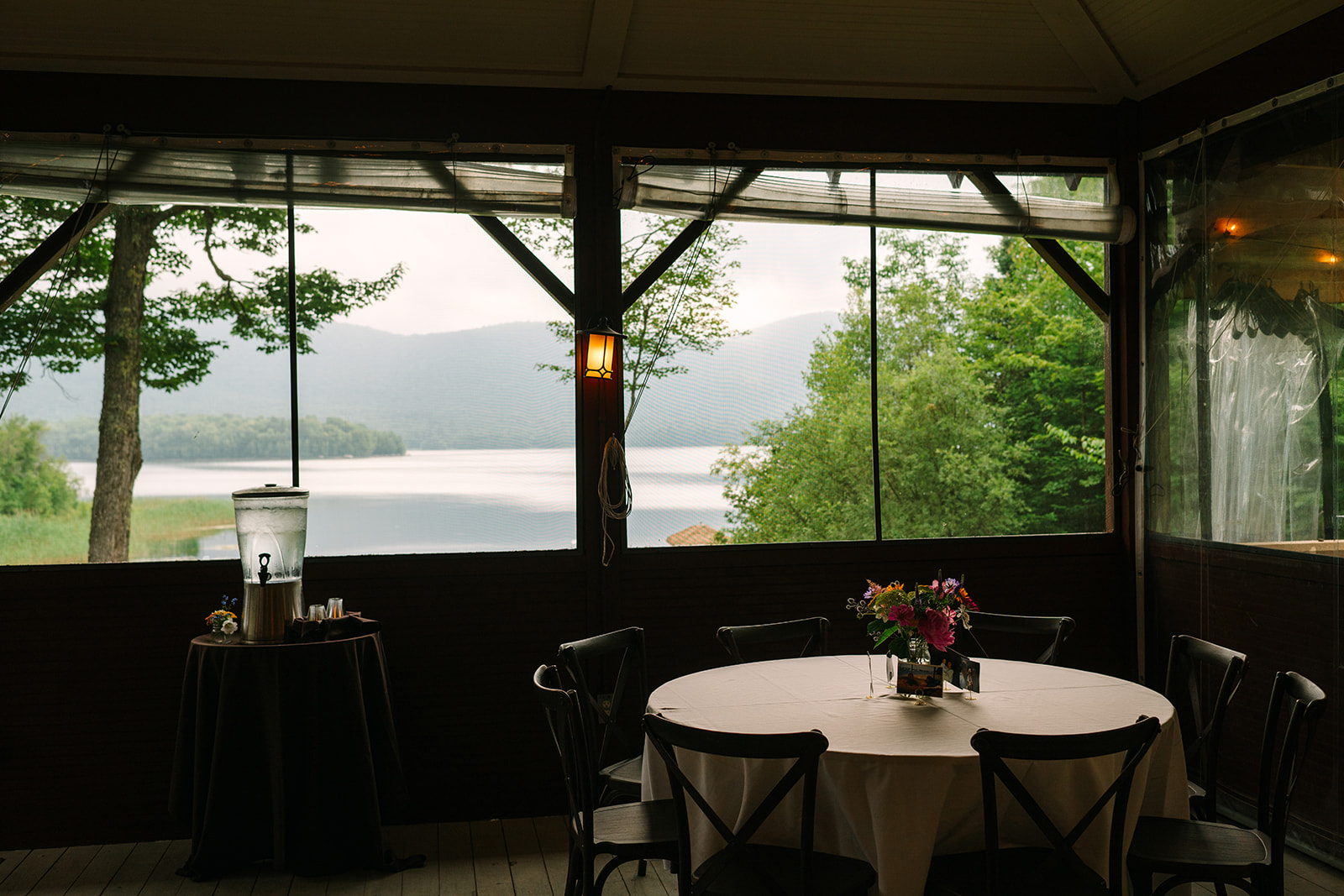 a table and chairs with flowers in front of a lake