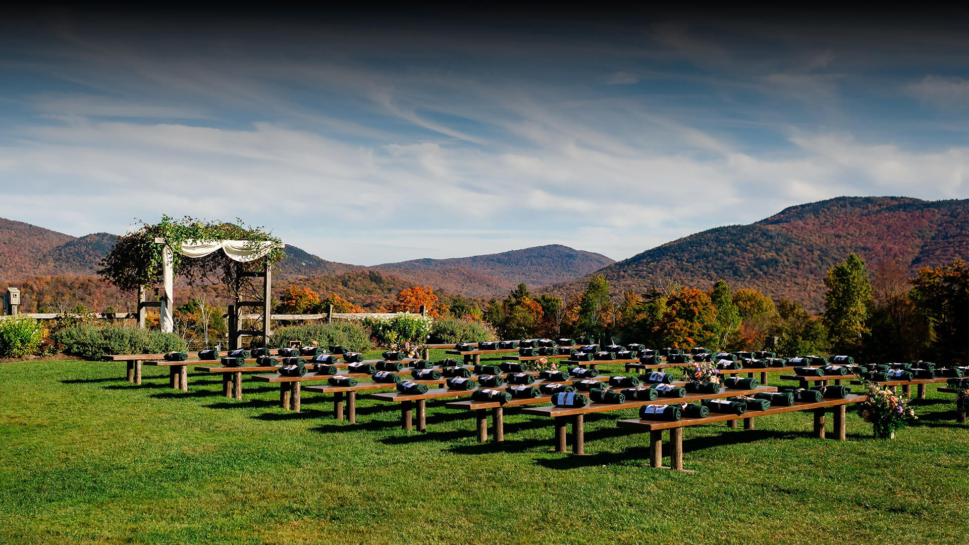 a large field of benches with a tent and mountains in the background
