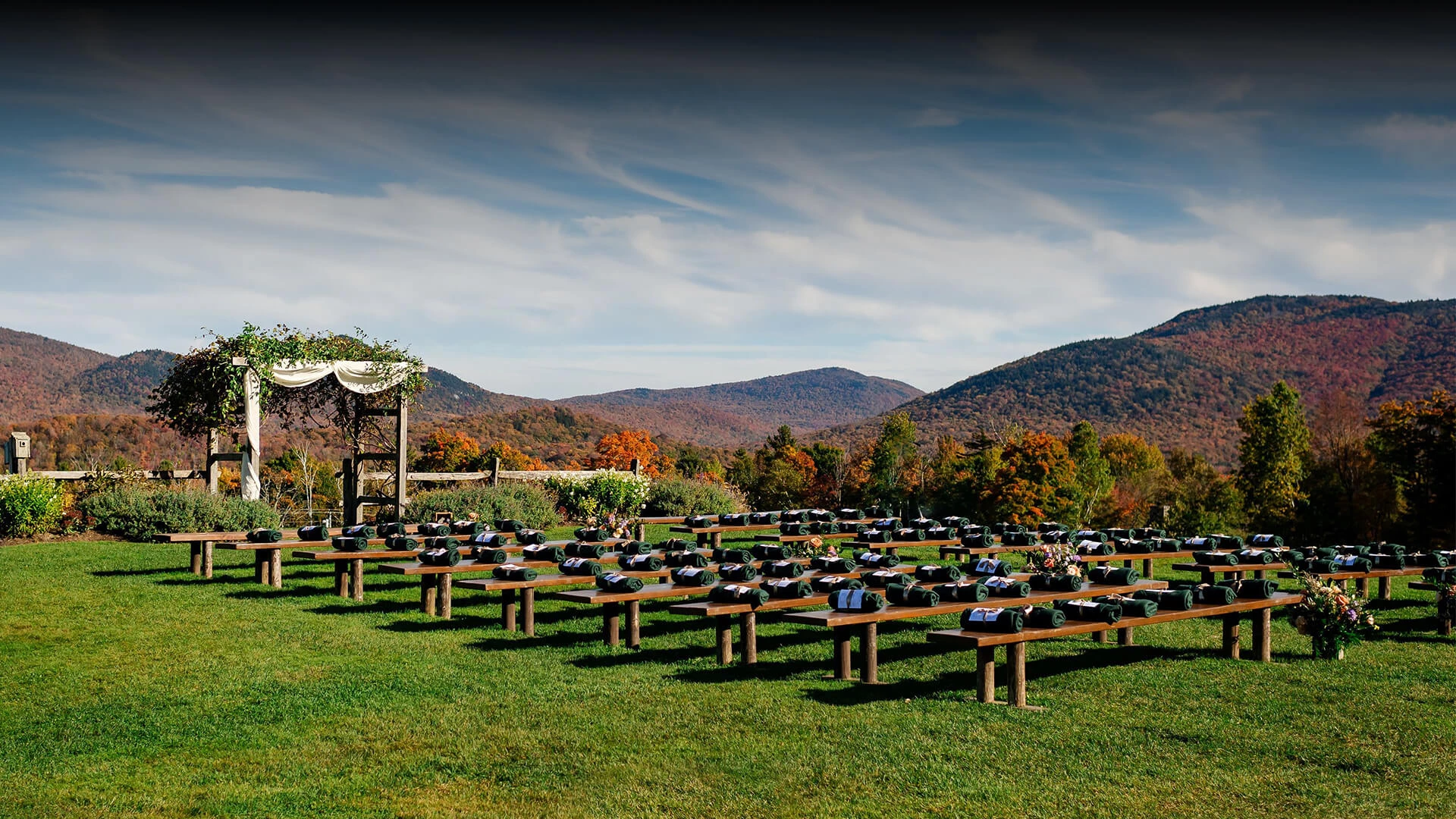 a large field of benches with a tent and mountains in the background