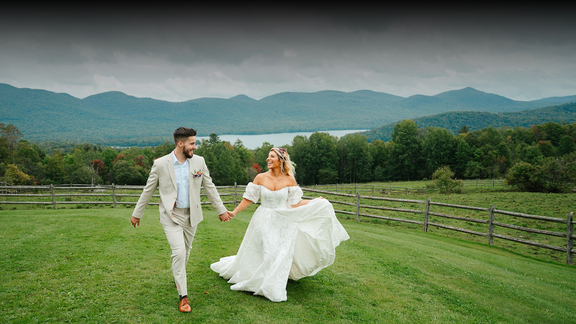 a man and woman holding hands and walking on grass