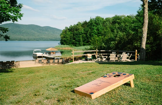 a wooden board on grass by a lake