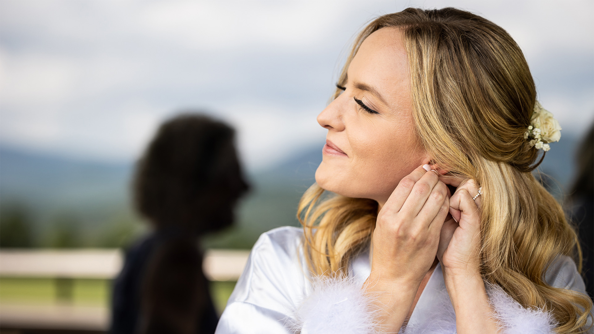 a woman adjusting her earrings